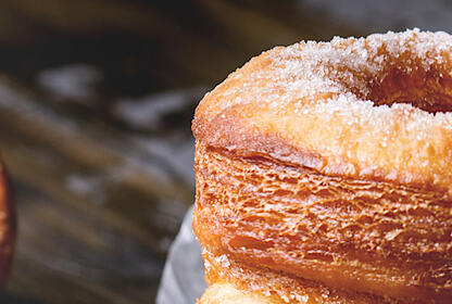 Three cronuts with one displaying the inside