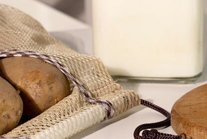 Potatoes milk presented in a glass and 2 bottles