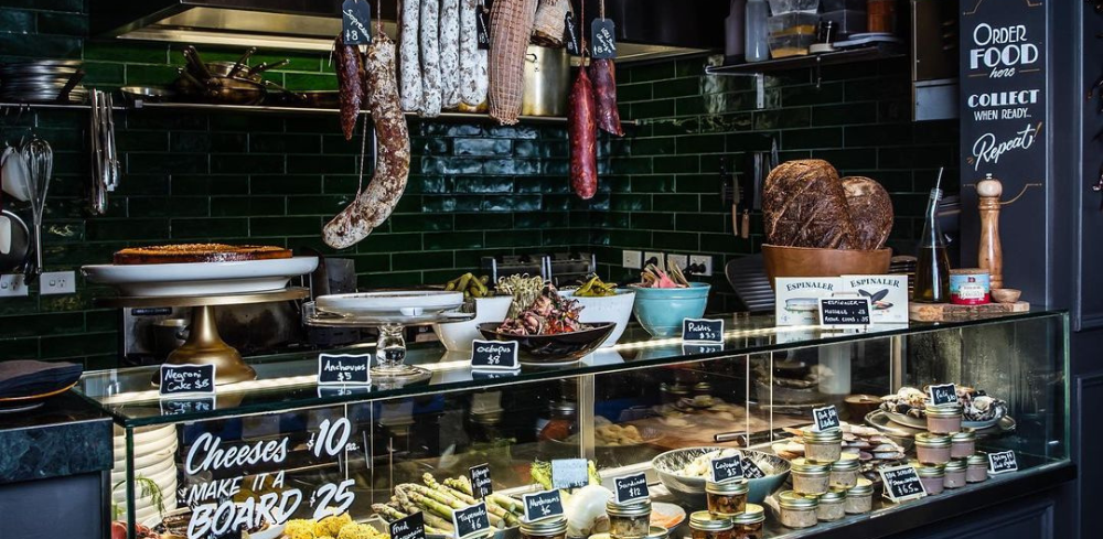 The shop counter at Black Bottle in Darlinghurst displaying French cheeses, cured meats and dessets