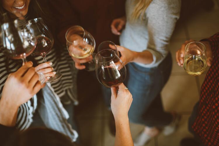 Des jeunes femmes trinquant avec plusieurs verres de vin blanc, rouge