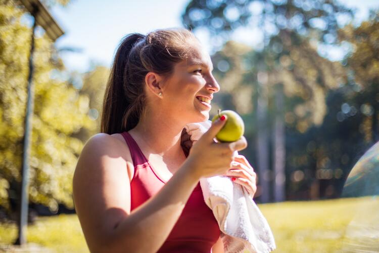 Woman eating fruit after sport session
