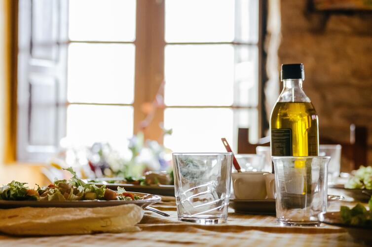 Bouteille d’huile d’olive sur une table dressée, super aliment bien-être et saveur