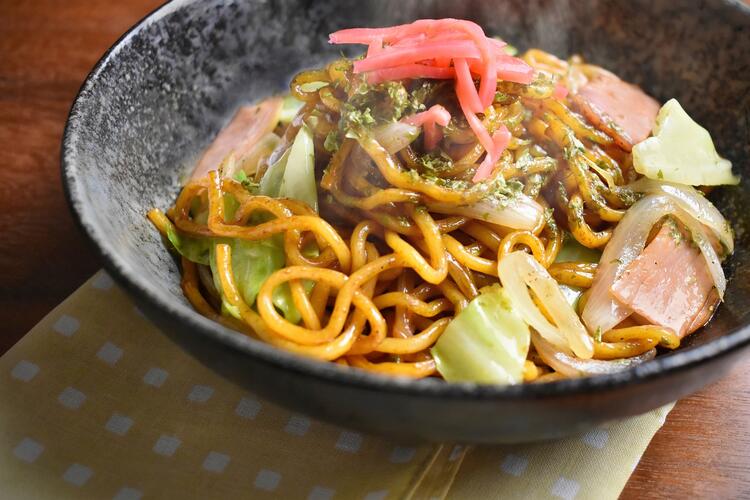 Grey bowl with noodles, meat, and vegetables: an iconic street food in Japan