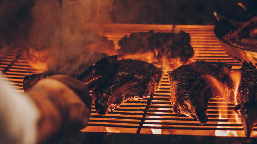 Steaks on a fiery, smoky grill