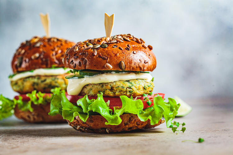 Lentil burger with lettuce, tomato, and dressing: example of plant-based protein source