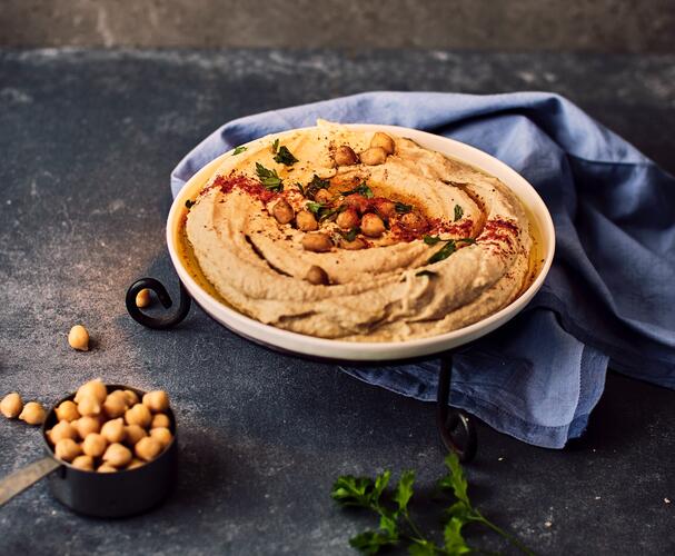 Serving of hummus with oil and chickpea garnish, example of easy plant-based protein source