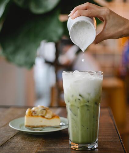 Glass of green milkshake with potato milk added