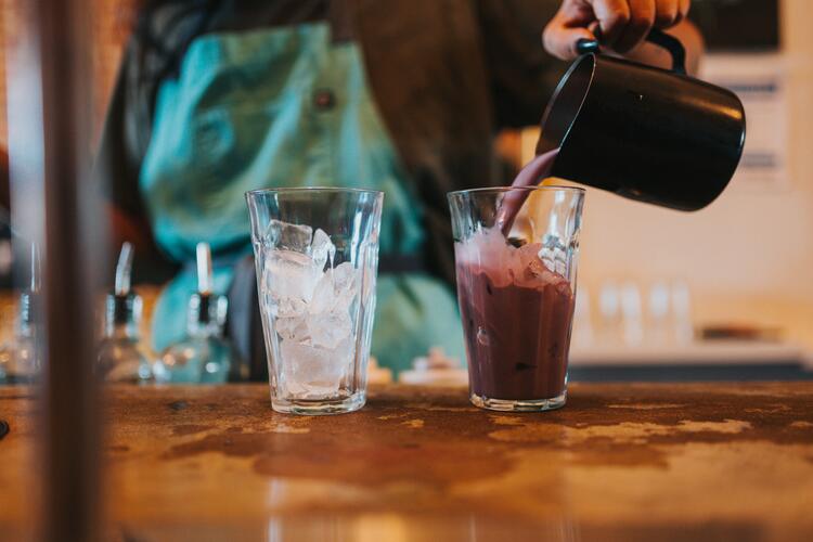Woman serving 2 glasses of fresh smoothies