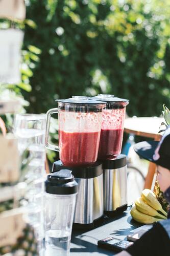 Blenders filled with fruits in an outdoor restaurant patio, place for a smoothie diet