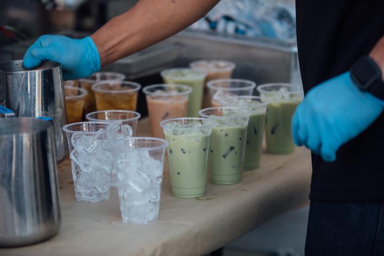 Man preparing glasses of bubble tea, with ice cubes and popping pearls