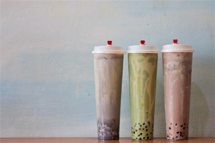Three plastic cups with different coloured bubble tea