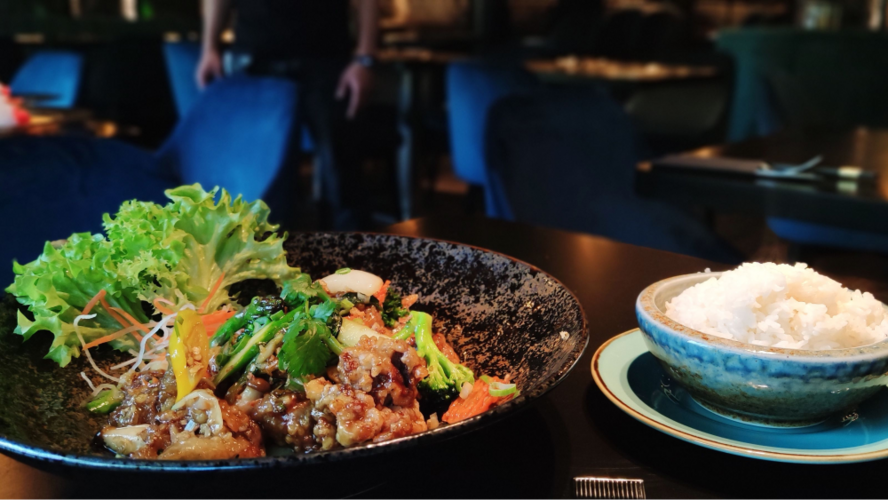 Asiatisches Gericht mit Gemüse und einer Schale Reis