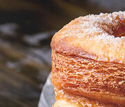 Three cronuts with one displaying the inside